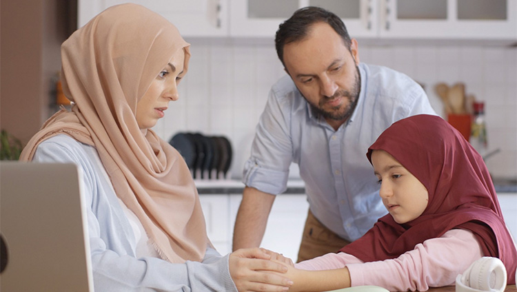 Parents discussing something with their child at the table.